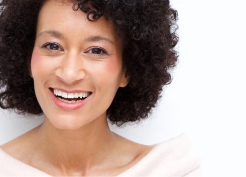 Photo of a smiling woman with dark, curly hair