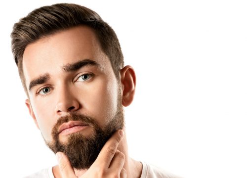 Photo of a man with a beard touching his chin